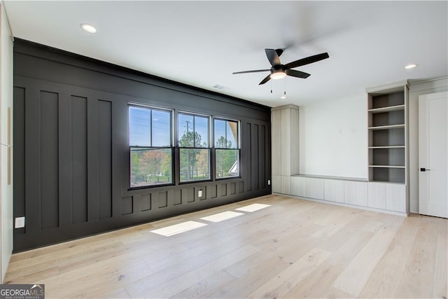 spare room featuring visible vents, wood finished floors, a decorative wall, ceiling fan, and recessed lighting