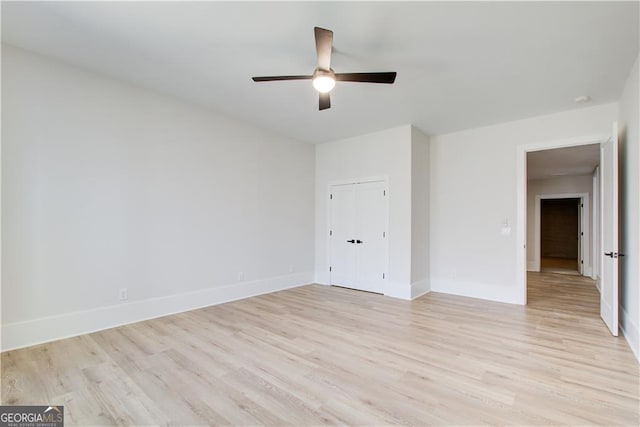 unfurnished room with baseboards, a ceiling fan, and light wood finished floors