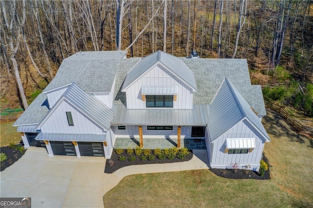 view of front of house featuring a standing seam roof, board and batten siding, metal roof, and a front yard