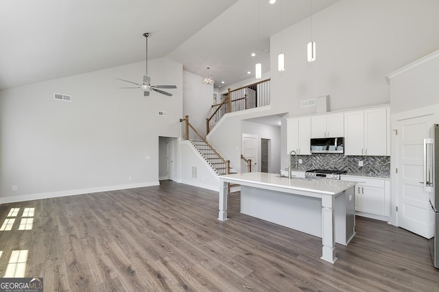 kitchen featuring visible vents, a sink, ceiling fan, appliances with stainless steel finishes, and high vaulted ceiling