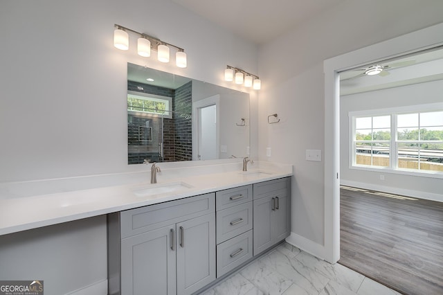 full bathroom with double vanity, baseboards, a sink, and a stall shower