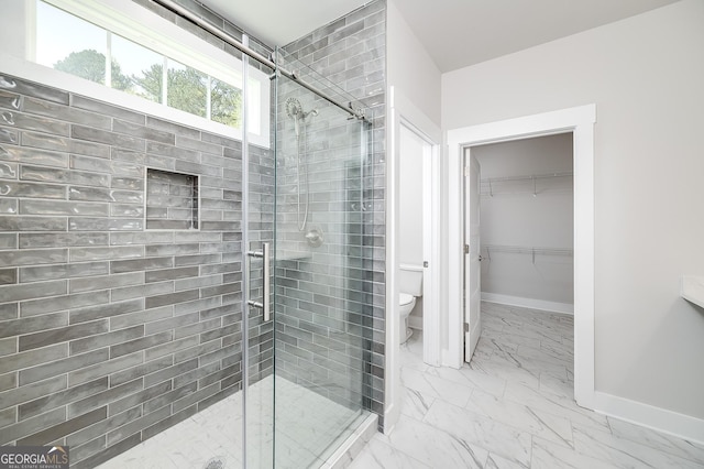 full bathroom with baseboards, toilet, a shower stall, a walk in closet, and marble finish floor
