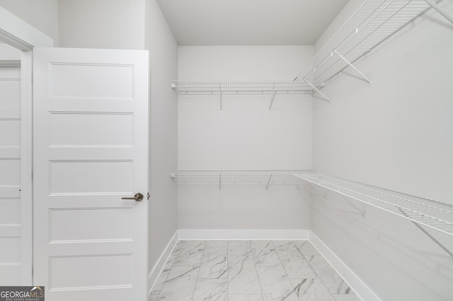 spacious closet featuring marble finish floor