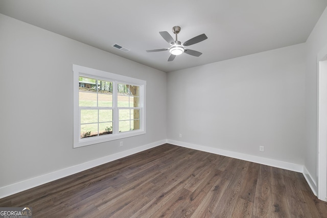 empty room featuring a ceiling fan, baseboards, dark wood-style floors, and visible vents
