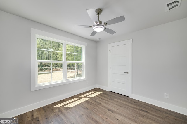 unfurnished room with visible vents, baseboards, a ceiling fan, and wood finished floors