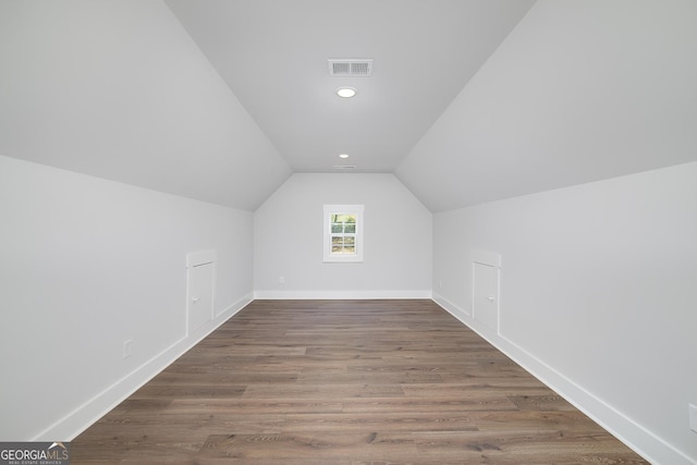 bonus room featuring wood finished floors, baseboards, vaulted ceiling, and visible vents