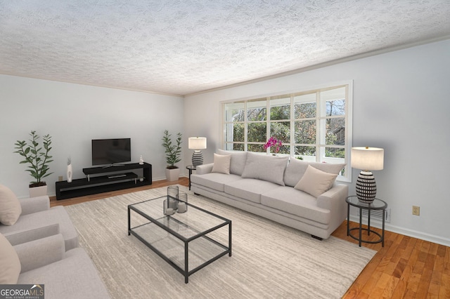 living area with baseboards, a textured ceiling, and hardwood / wood-style floors