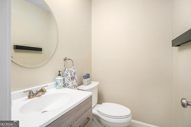 half bath featuring vanity and toilet