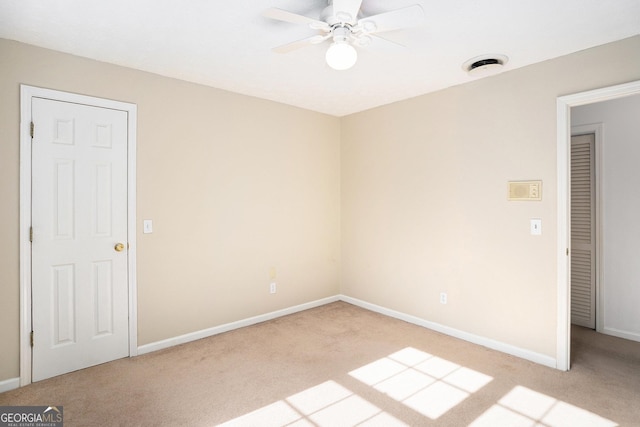 unfurnished room featuring baseboards, ceiling fan, and light colored carpet