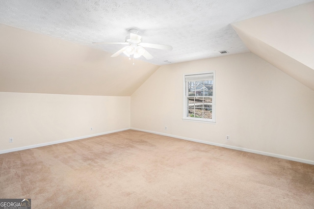 additional living space featuring carpet floors, a ceiling fan, baseboards, and vaulted ceiling