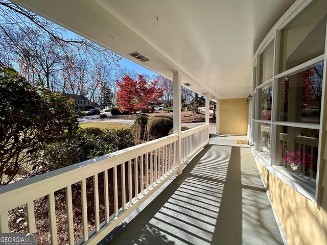 traditional home with fence, an attached garage, a front yard, driveway, and a porch