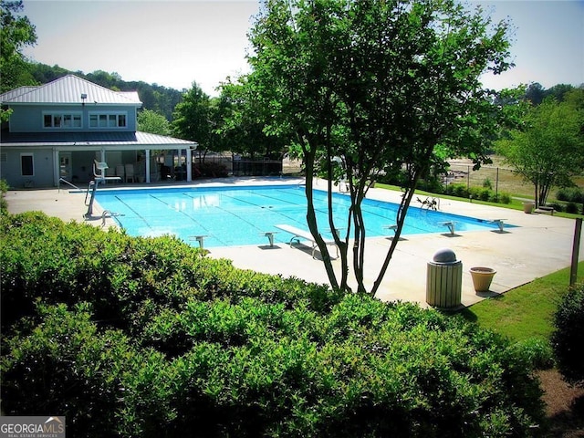 view of pool featuring a diving board, fence, a patio area, and a fenced in pool