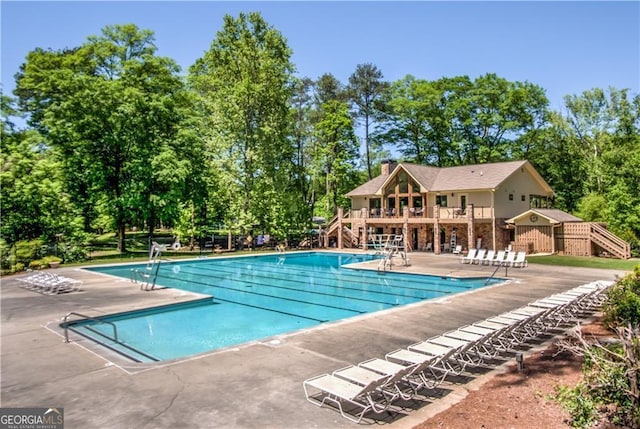 community pool with stairs and a patio area