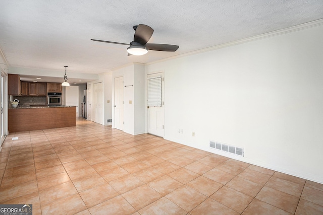unfurnished living room with crown molding, a ceiling fan, visible vents, and light tile patterned flooring