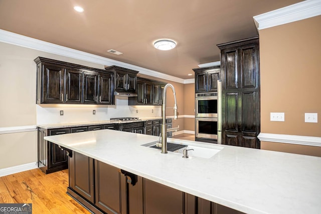 kitchen featuring light countertops, crown molding, visible vents, appliances with stainless steel finishes, and a sink