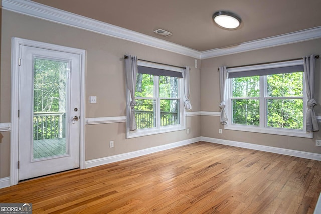 doorway to outside with visible vents, baseboards, plenty of natural light, light wood-type flooring, and crown molding