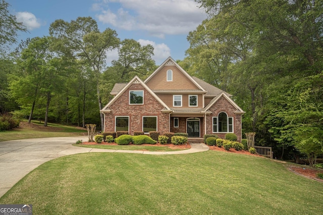 craftsman inspired home featuring brick siding, a front lawn, and concrete driveway