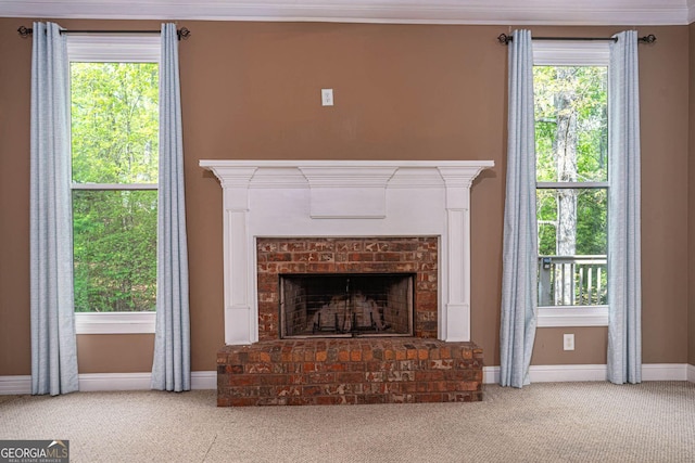 unfurnished living room with baseboards, carpet, a brick fireplace, and a healthy amount of sunlight