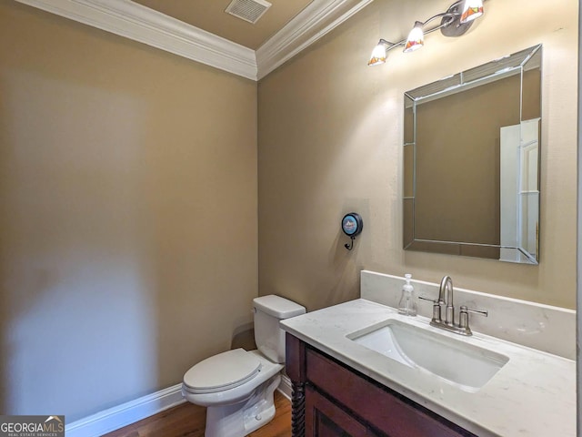 half bathroom with visible vents, toilet, crown molding, vanity, and wood finished floors