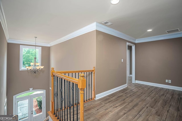 hallway with a chandelier, an upstairs landing, visible vents, and wood finished floors