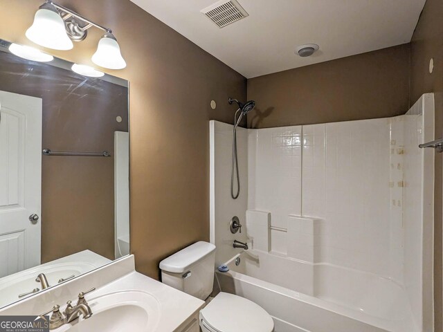 bathroom featuring visible vents, toilet, vanity, and shower / washtub combination