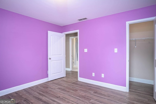 unfurnished bedroom with a closet, baseboards, and wood finished floors