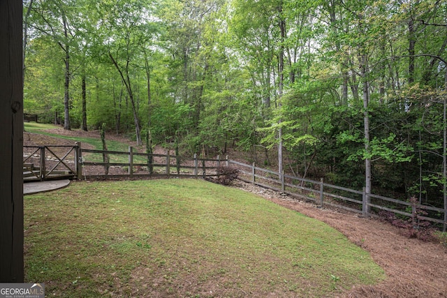 view of yard featuring a view of trees and fence