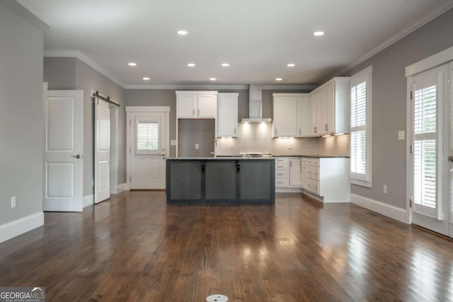215 Chapman Pl, Athens, GA 30606 - kitchen with wall chimney range hood, a barn door, crown molding, white cabinets, and backsplash