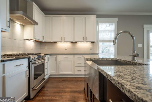215 Chapman Pl, Athens, GA 30606 - kitchen with wall chimney range hood, gas range, decorative backsplash, ornamental molding, and white cabinetry