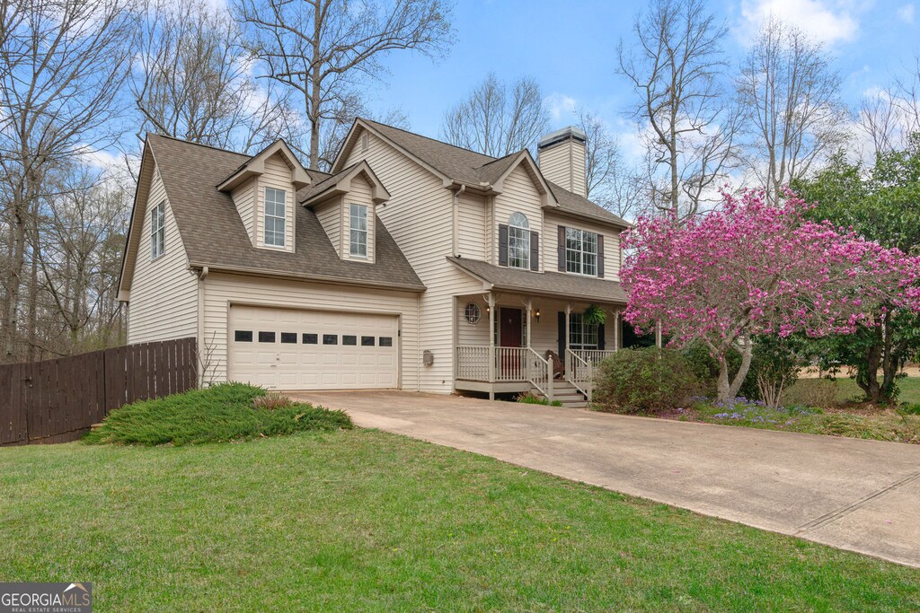 7810 Rose Ct, Cumming, GA 30040 - view of front of house with concrete driveway, a chimney, fence, a garage, and a porch