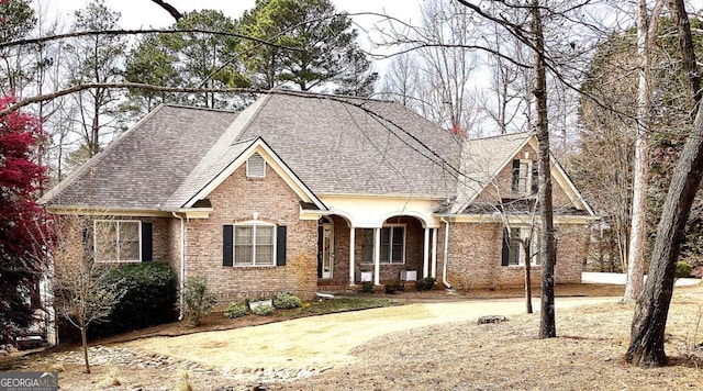 view of front of home with brick siding and a shingled roof