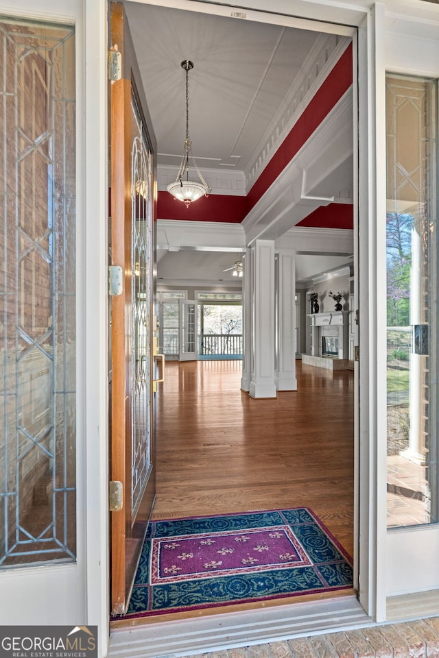 hallway with ornamental molding and wood finished floors