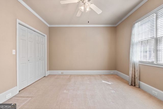 unfurnished bedroom featuring a closet, ornamental molding, baseboards, and carpet