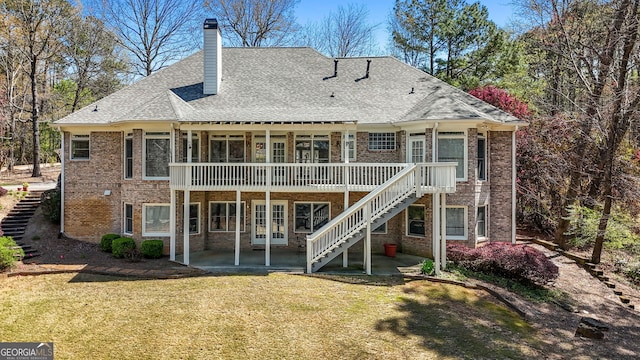 back of property with brick siding, stairway, and a yard