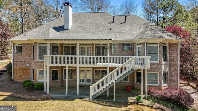 rear view of property featuring french doors, brick siding, stairway, and a patio