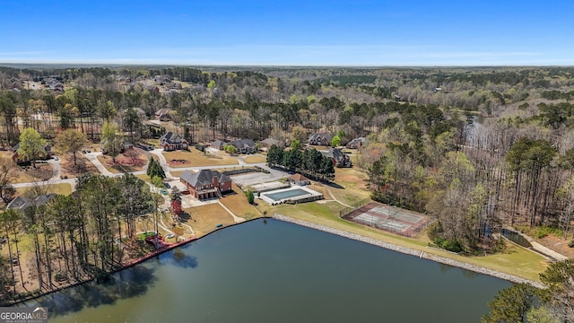 birds eye view of property featuring a water view and a view of trees