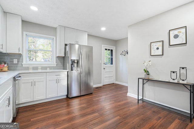 1013 Columbia Dr, Decatur, GA 30030 - kitchen with appliances with stainless steel finishes, dark wood-type flooring, tasteful backsplash, light countertops, and white cabinets