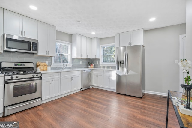 1013 Columbia Dr, Decatur, GA 30030 - kitchen with stainless steel appliances, backsplash, light countertops, white cabinets, and recessed lighting