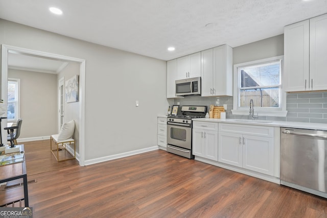 1013 Columbia Dr, Decatur, GA 30030 - kitchen with stainless steel appliances, light countertops, dark wood-style floors, tasteful backsplash, and recessed lighting