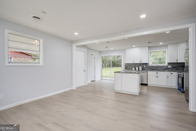 2352 Helsinki Dr, Augusta, GA 30906 - kitchen with light wood-type flooring, stainless steel appliances, backsplash, a sink, and white cabinets