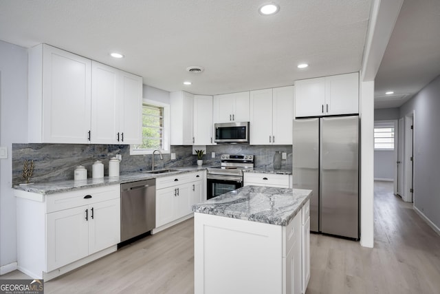 2352 Helsinki Dr, Augusta, GA 30906 - kitchen with white cabinetry, tasteful backsplash, light wood-type flooring, and appliances with stainless steel finishes