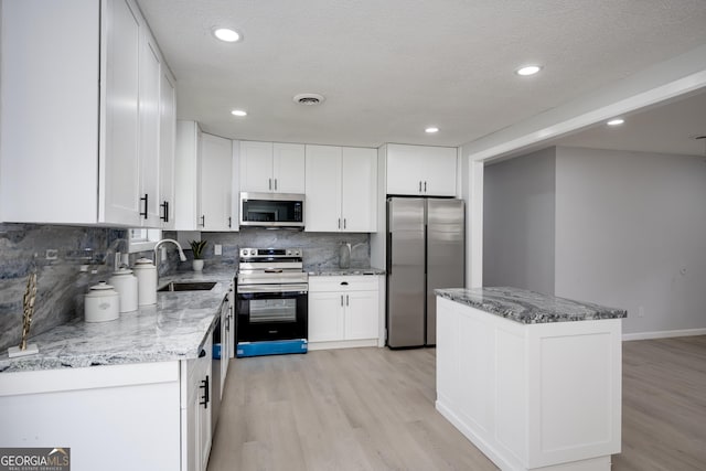 2352 Helsinki Dr, Augusta, GA 30906 - kitchen with white cabinetry, a sink, stainless steel appliances, and light wood finished floors