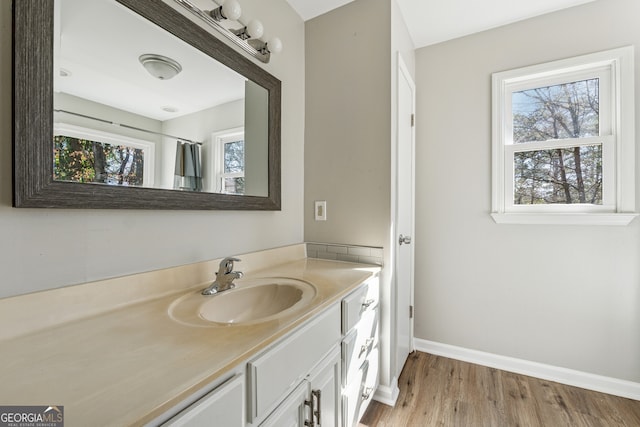 bathroom featuring vanity, baseboards, and wood finished floors