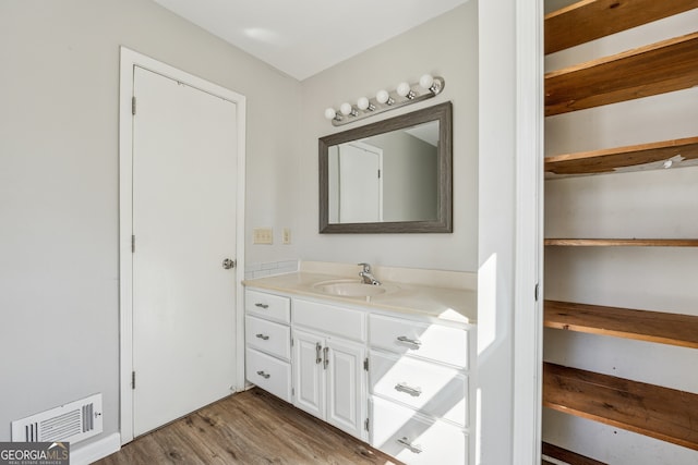 bathroom with visible vents, vanity, and wood finished floors