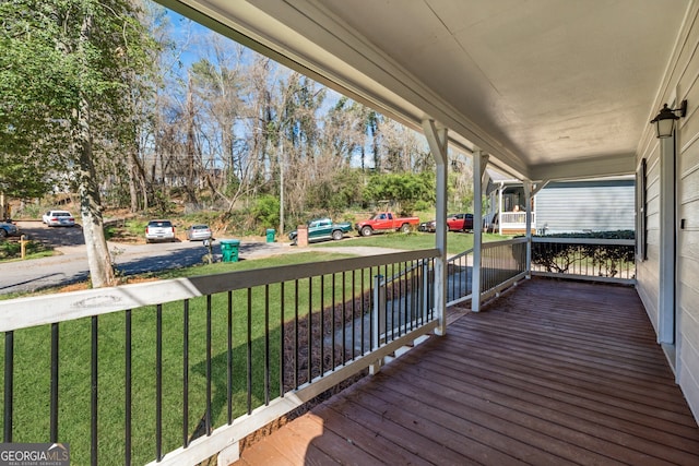 wooden terrace with a porch and a lawn