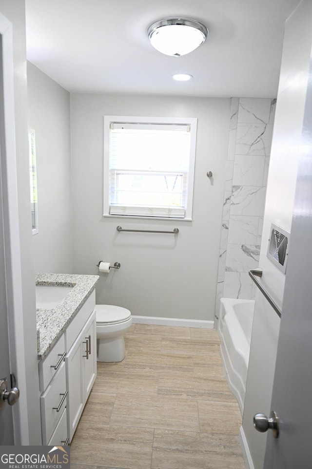 bathroom with baseboards, toilet, and vanity