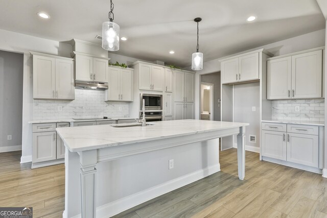 8 Sumner Way, Senoia, GA 30276 - kitchen featuring light wood-type flooring, a sink, tasteful backsplash, and stainless steel appliances