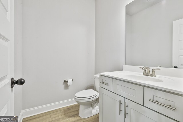 8 Sumner Way, Senoia, GA 30276 - half bathroom with vanity, baseboards, wood finished floors, and toilet