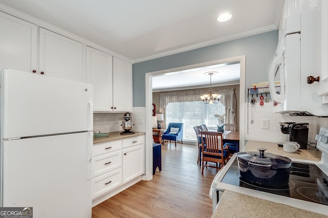 2926 Westbury Dr, Decatur, GA 30033 - kitchen with white cabinetry, a chandelier, crown molding, and white appliances