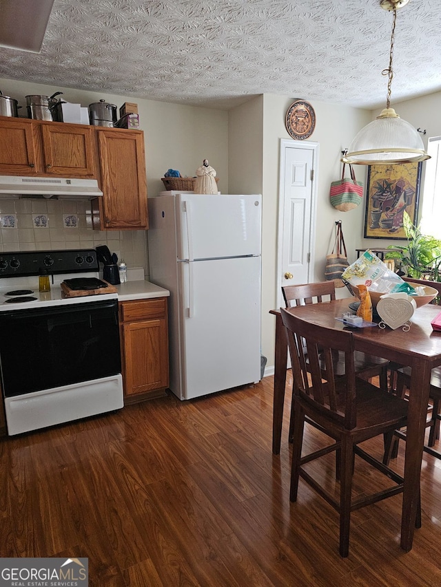 315 Saratoga Pl, Riverdale, GA 30296 - kitchen with tasteful backsplash, brown cabinets, white appliances, under cabinet range hood, and dark wood-type flooring